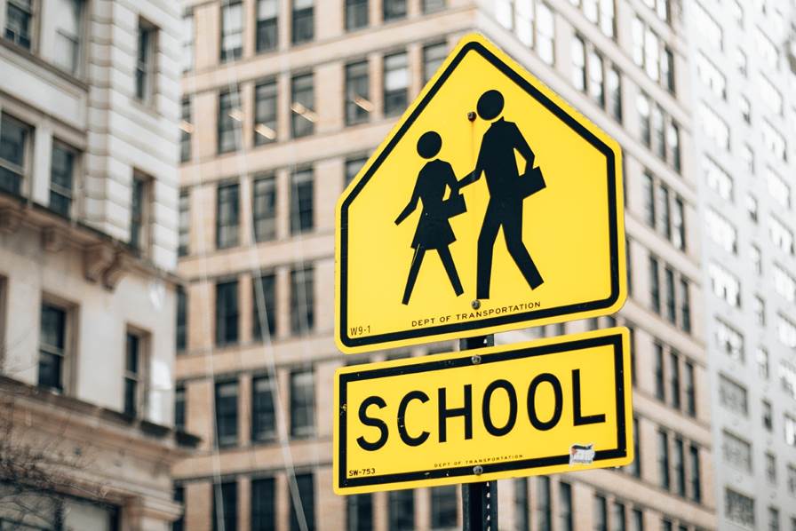 A yellow sign with a black and white image of a school crossing

AI-generated content may be incorrect.